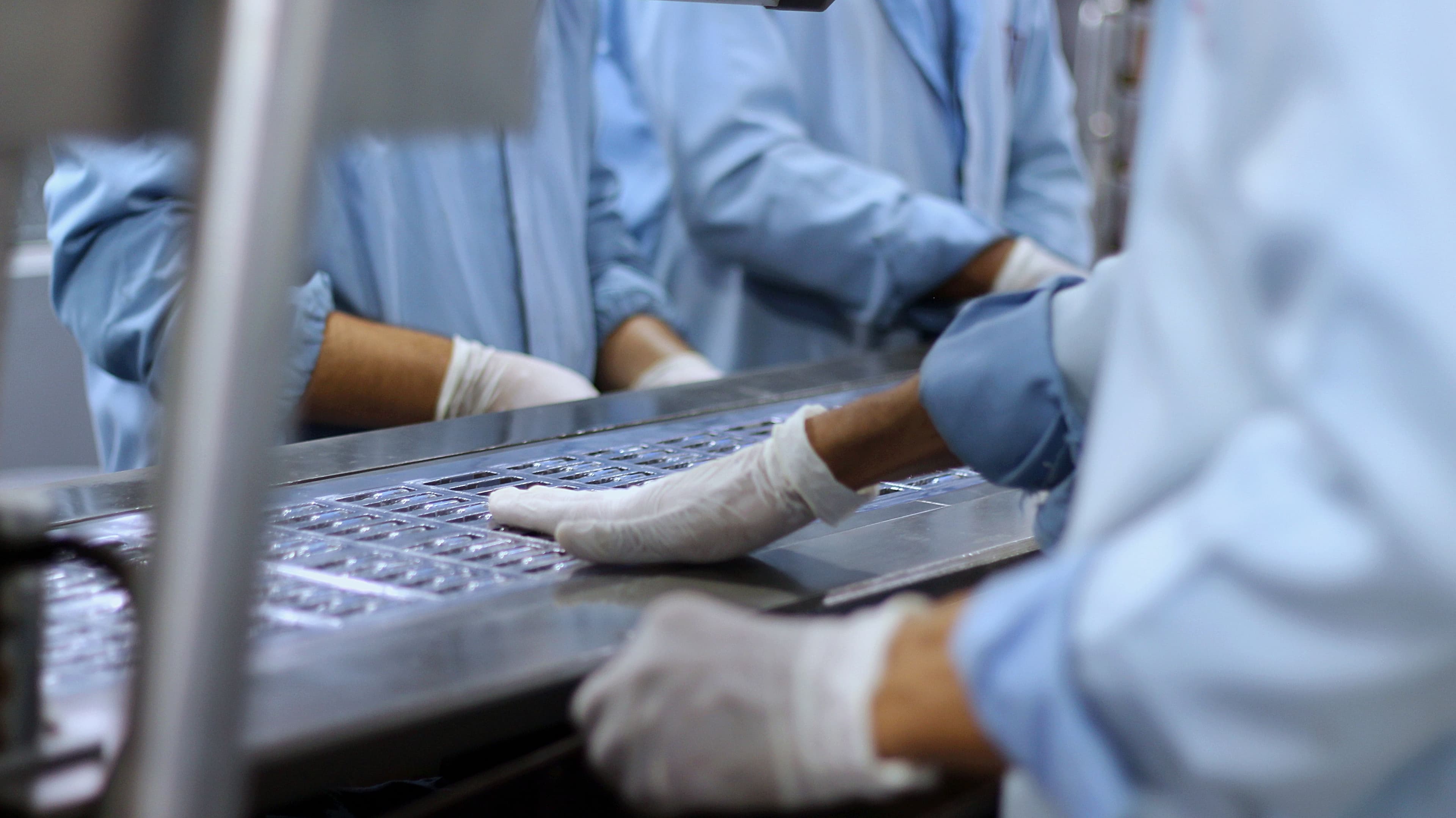 Operarios trabajando en una línea de producción farmacéutica
